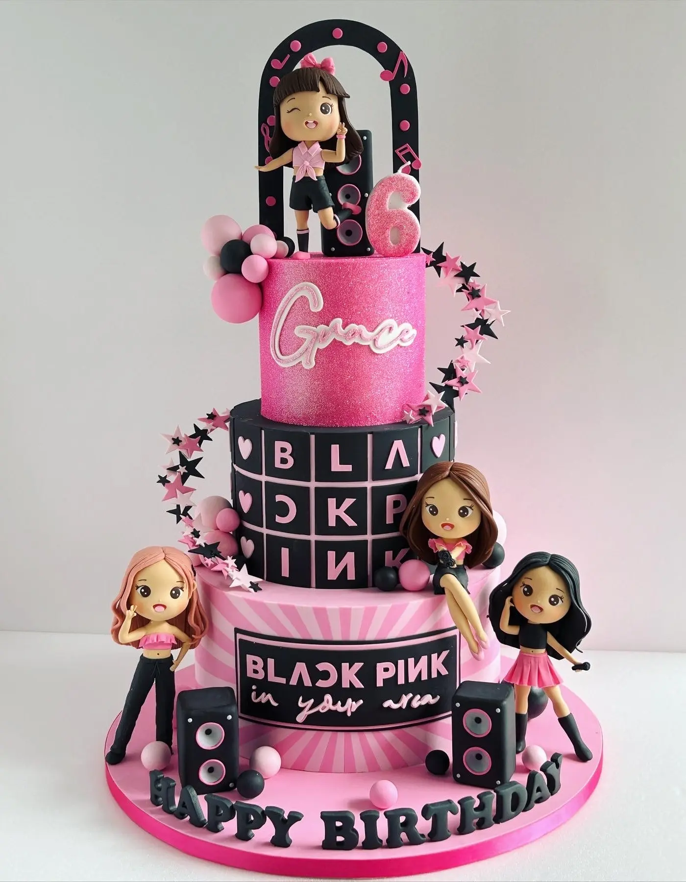 Pink and black BLACKPINK-themed three-tier birthday cake with K-pop figurines